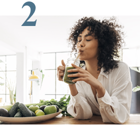 woman drinking green smoothie in apartment